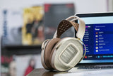 HiFiMAN HE1000 WiFi streaming planar headphones, on a desk beside a laptop