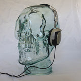 AMP3 glass skull headphone stand, clear, with headphones